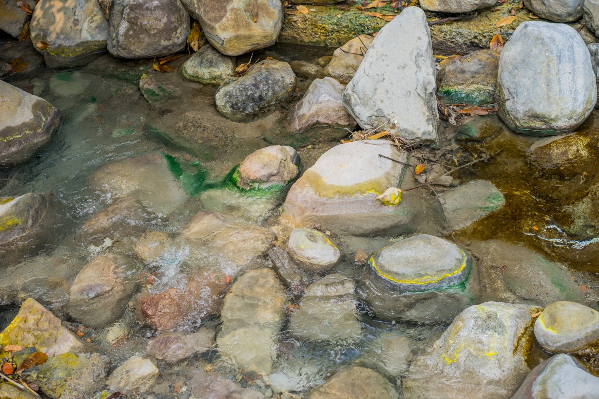 温泉水常年流过，在石头上留下了各色的硫磺